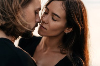 Çekici erkek ve kadın gün batımında romantik bir akşam geçiriyorlar.