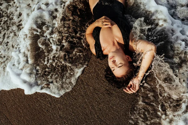 Retrato de una hermosa mujer de moda deportiva en bikini negro posando en verano cerca del océano —  Fotos de Stock