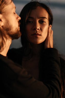 Çekici erkek ve kadın gün batımında romantik bir akşam geçiriyorlar.