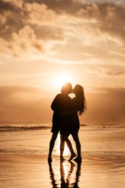 Çekici erkek ve kadın gün batımında romantik bir akşam geçiriyorlar.