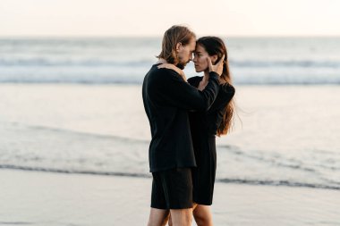 Çekici erkek ve kadın gün batımında romantik bir akşam geçiriyorlar.