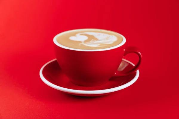 Hot cappuccino on red table — Stock Photo, Image