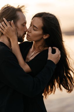 Çekici erkek ve kadın gün batımında romantik bir akşam geçiriyorlar.