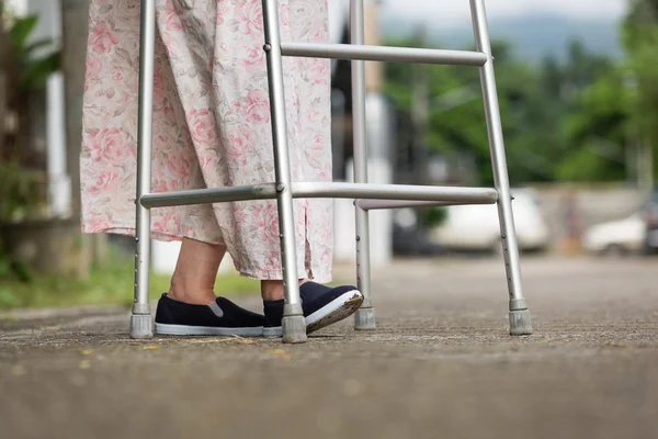 Mulher idosa usando um andador na rua . — Fotografia de Stock
