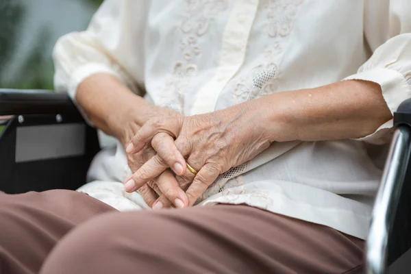 Ouderen handen op een rolstoel. — Stockfoto