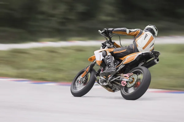 Motorcycle practice leaning into a fast corner on track — Stock Photo, Image