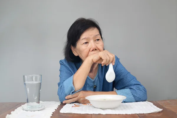 Idosos asiático mulher entediado com alimentos — Fotografia de Stock