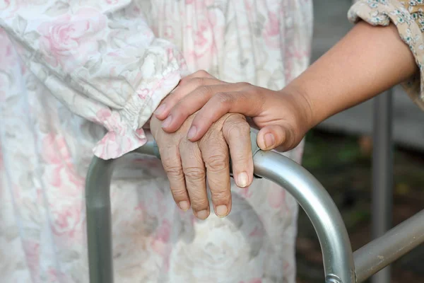 Старшая женщина сидит использовать ходунки с воспитателем — стоковое фото