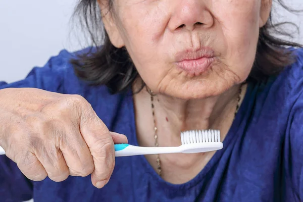 Пожилая азиатка с зубной щеткой. Здоровье зубов — стоковое фото