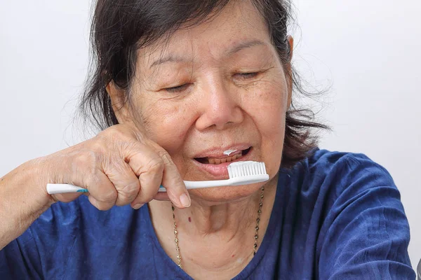 Asiática anciana tratando de usar cepillo de dientes, temblor de manos  . —  Fotos de Stock