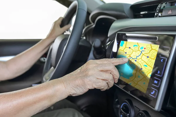 Пожилая женщина использует GPS навигационную систему в автомобиле — стоковое фото