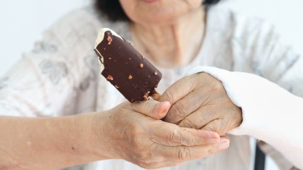 Elderly woman broken wrist enjoying ice cream — Stock Video