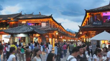 Akşam Lijiang 'ın eski kasabasında kargalı bir turist vardı..