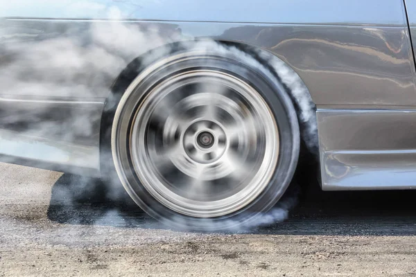 Race car burns rubber off its tires in preparation for the race — Stok fotoğraf