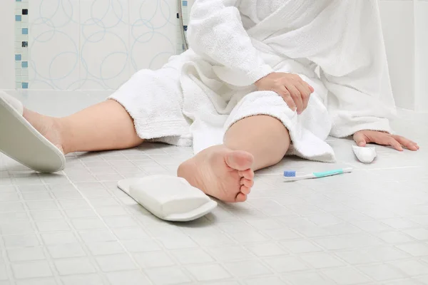 Женщина падает в ванной, потому что скользкие поверхности — стоковое фото