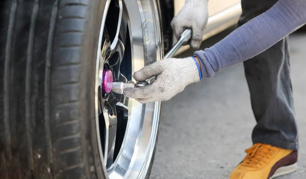 Auto mechanik mění závodní auto kola — Stock fotografie