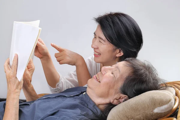 Bejaarde vrouw lezen Fabel boek met dochter — Stockfoto