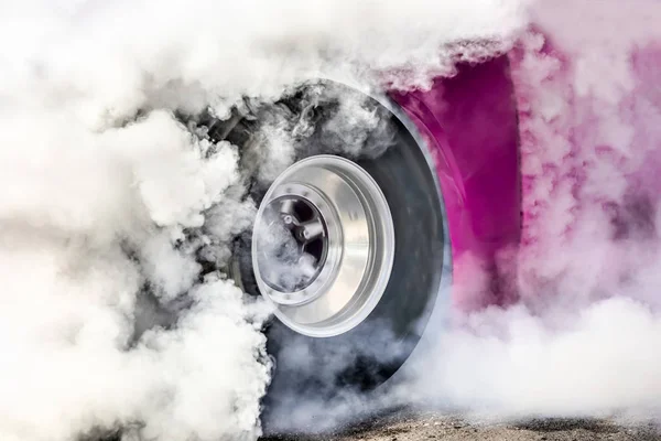 Arrastre coche de carreras quema caucho de sus neumáticos en preparación para la carrera —  Fotos de Stock