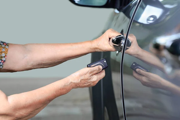 Starší žena ruku otevřené auto na klíčových automobilové alarmové systémy — Stock fotografie