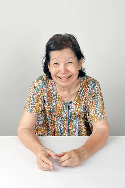 Anciana sonriente, sentada sobre fondo blanco —  Fotos de Stock