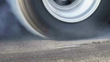 Sürüklenen yarış arabası yarışa hazırlanırken lastiklerini yakıyor.