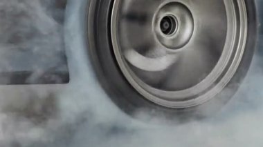 Sürüklenen yarış arabası yarışa hazırlanırken lastiklerini yakıyor.