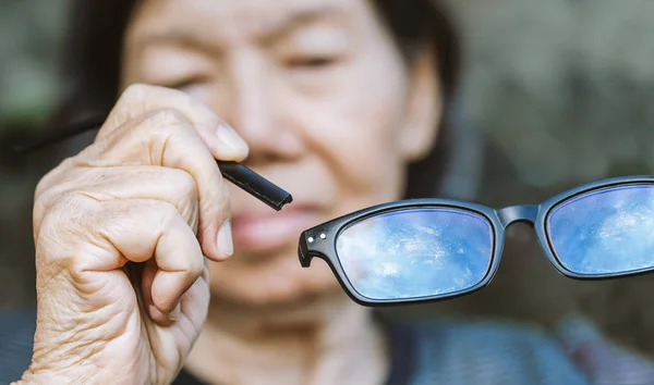 Ancianos mujer asiática reparación roto gafas — Foto de Stock