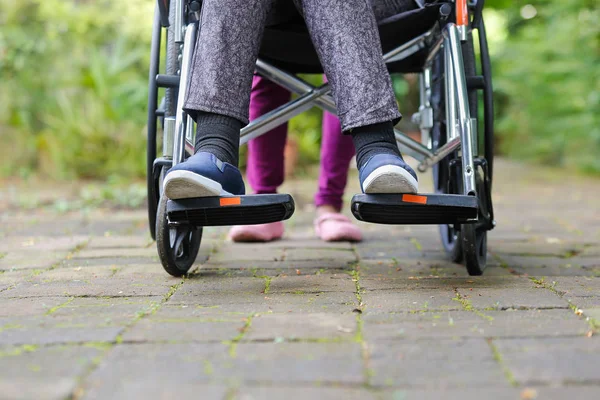 老妇在轮椅行走与照顾者 — 图库照片