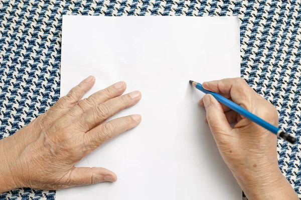 Femme âgée écrivant sur papier blanc — Photo