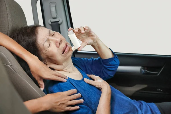 Mujer anciana ahogándose y sosteniendo un spray de asma dentro del coche —  Fotos de Stock