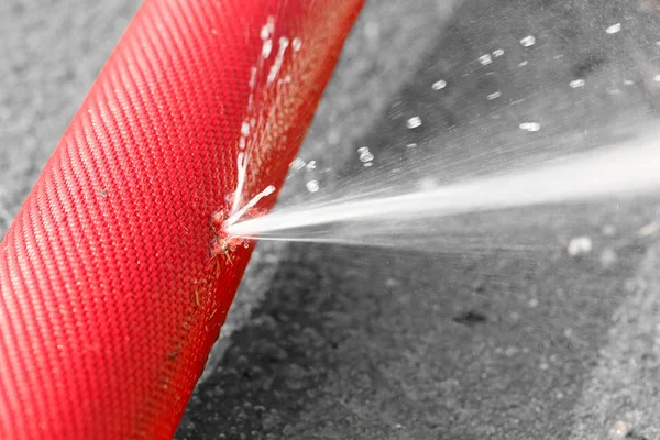 Water leaking from hole in a hose — Stock Photo, Image