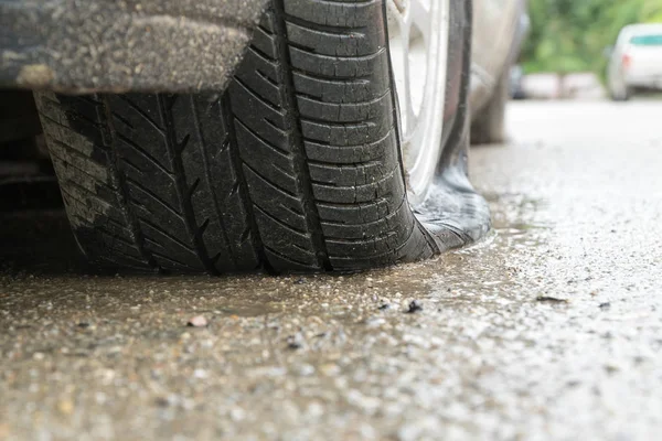 yağmurlu bir gün sokakta arabaya düz lastik.