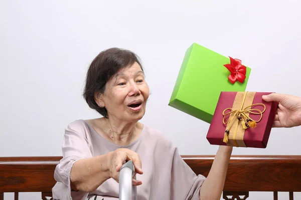 Mujer mayor recibiendo un regalo de su hija —  Fotos de Stock