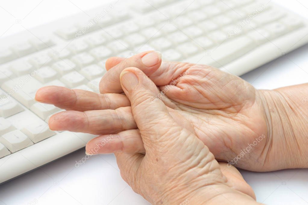 Senior woman painful finger due to prolonged use of keyboard and mouse