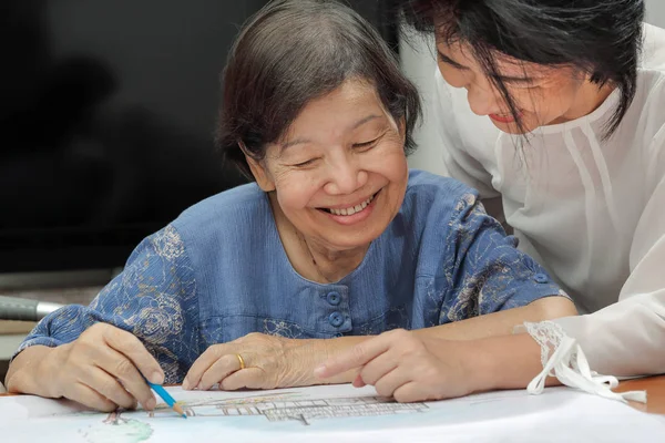 她带着女儿，在家里的爱好的绘图上的老妇绘画色彩 — 图库照片