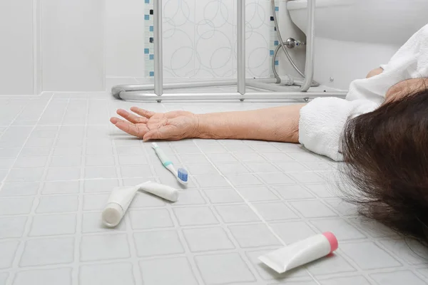 Oudere vrouw vallen in de badkamer omdat gladde oppervlakken — Stockfoto