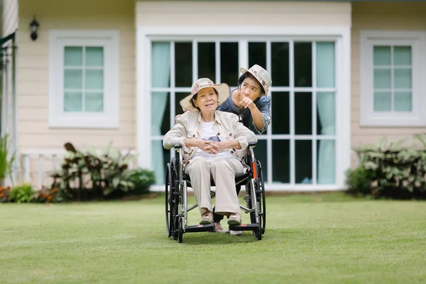 老妇在后院的轮椅上放松与女儿 — 图库照片