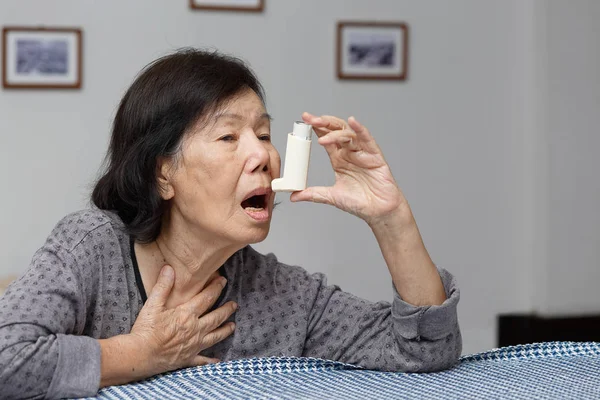 Mujer mayor asfixiándose y sosteniendo un aerosol de asma —  Fotos de Stock