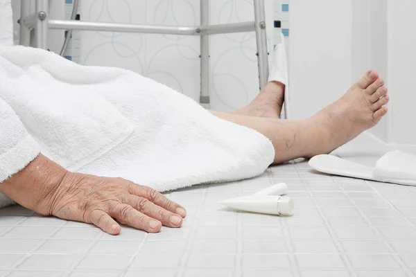 Пожилая женщина падает в ванной, потому что скользкие поверхности — стоковое фото