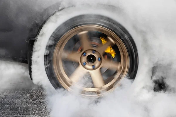 Sürüklenen yarış arabası yarışa hazırlanırken lastiklerini yakıyor. — Stok fotoğraf