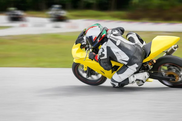 Práctica de la motocicleta inclinándose en una esquina rápida en la pista — Foto de Stock