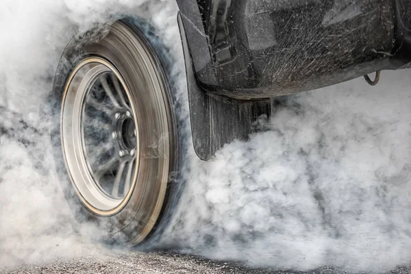 Drag racing bil bränner gummi av sina däck som förberedelse för loppet — Stockfoto
