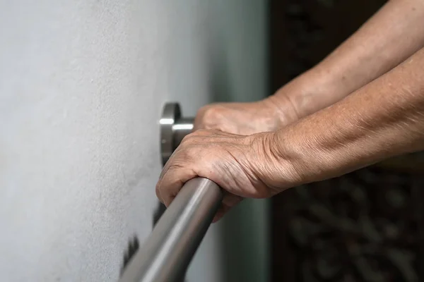 Mujer anciana sosteniendo la mano en la barandilla para caminar de apoyo — Foto de Stock