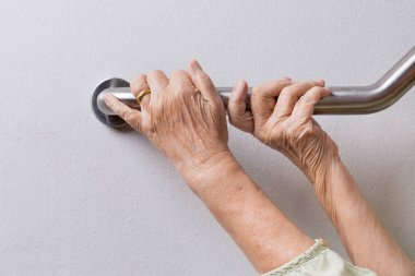 Küpeşte güvenliği için üzerinde tutan yaşlı kadın yürümek adımları