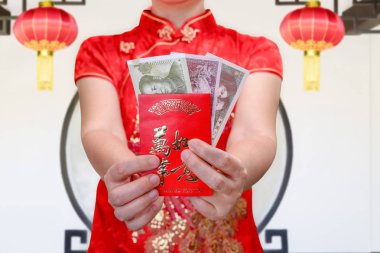 Çinli kadın yeni yıl kırmızı zarf veya hong bao, metin sizin için ortalama en iyi diler holding.