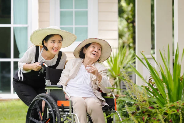 Bejaarde vrouw tuinieren in de achtertuin met dochter — Stockfoto