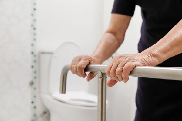 Mujer mayor sosteniendo en pasamanos en el baño . — Foto de Stock