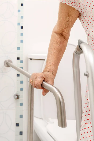 Femme âgée tenant la main courante dans les toilettes . — Photo