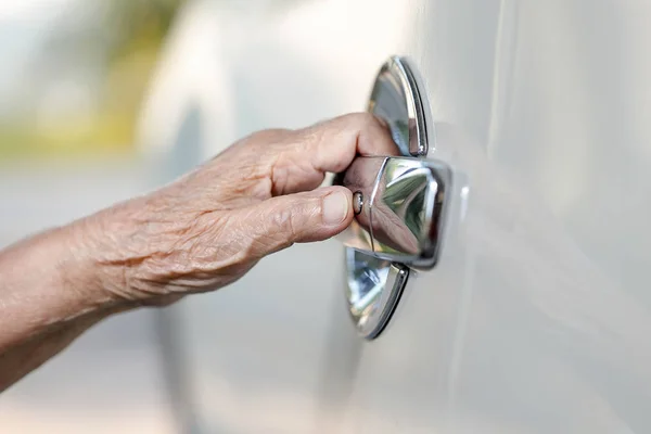 Elderly woman hand opening car door — Stock Photo, Image