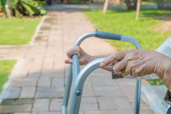 Bejaarde vrouw met behulp van walker in achtertuin — Stockfoto